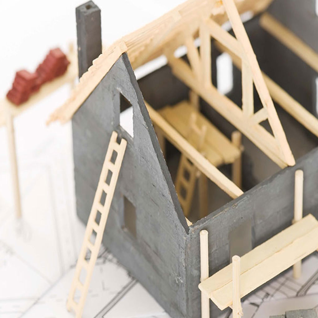 A wooden house in the process of being rebuilt.