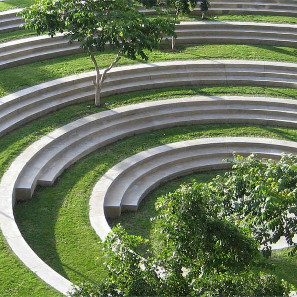 A grassy tiered seating area with stone seats