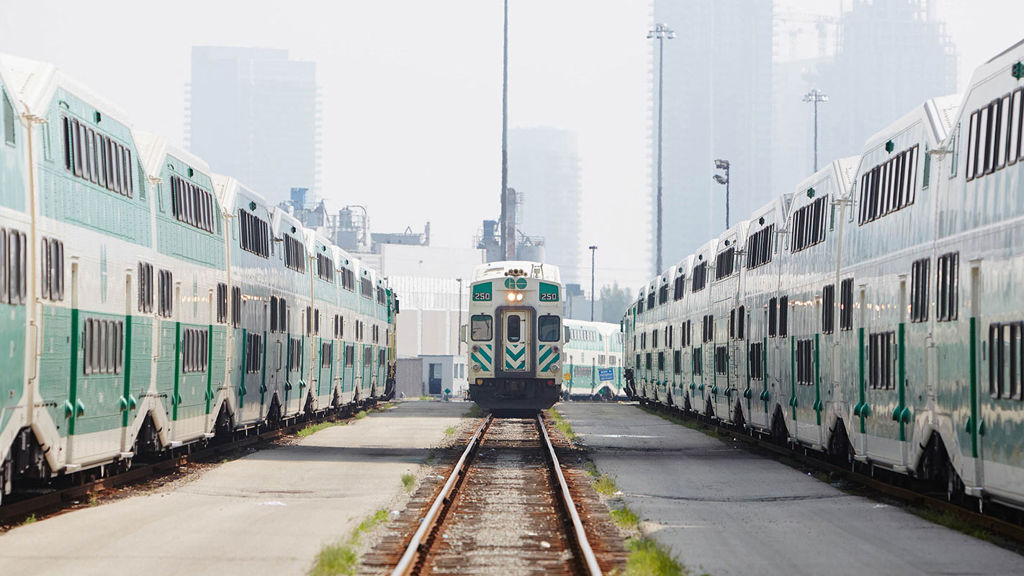GO Transit train yard with train coming towards camera from afar, trains flanking on adjacent tracks