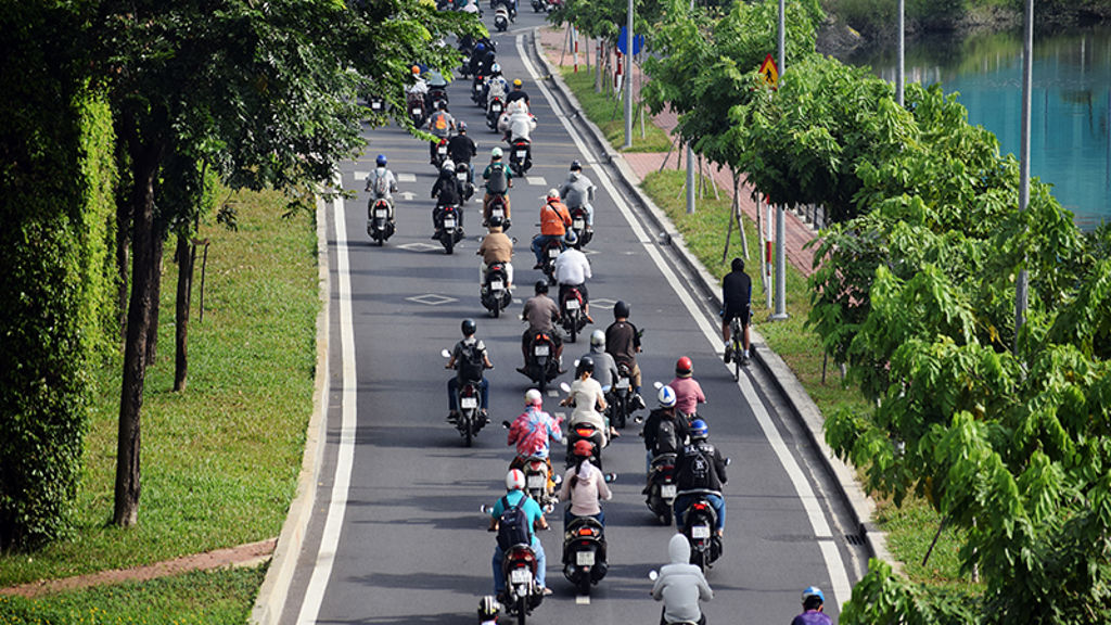 A group of people riding motorcycles down a road.
