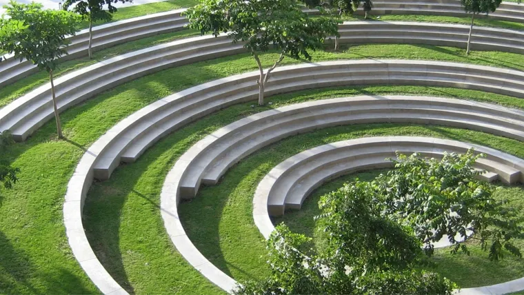 A grassy tiered seating area with stone seats