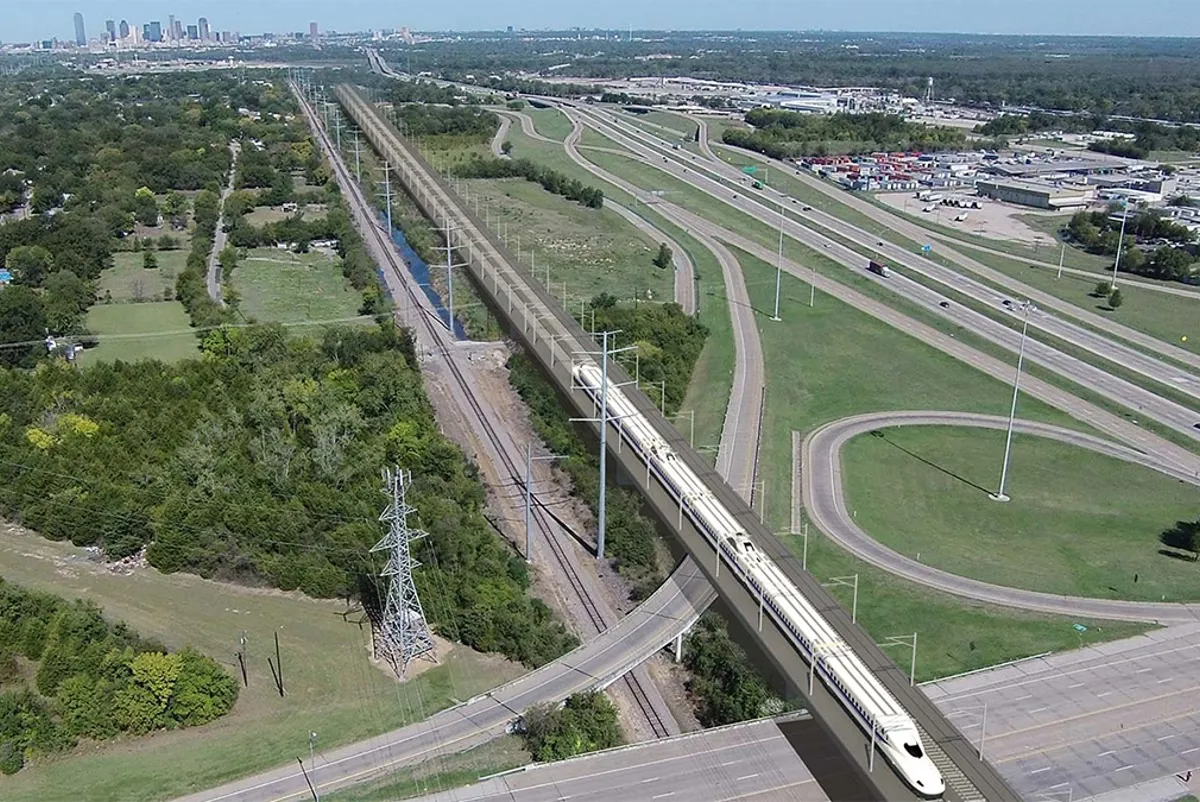 An elevated high-speed train traveling over a highway